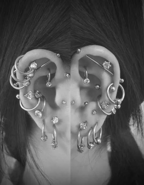 耳のピアス。左右の耳たぶ、ヘリックス、インダストリアル、コンク、アウターコンク、ロック、スナッグ、アンチトラガス等様々に複数個の耳のピアス。