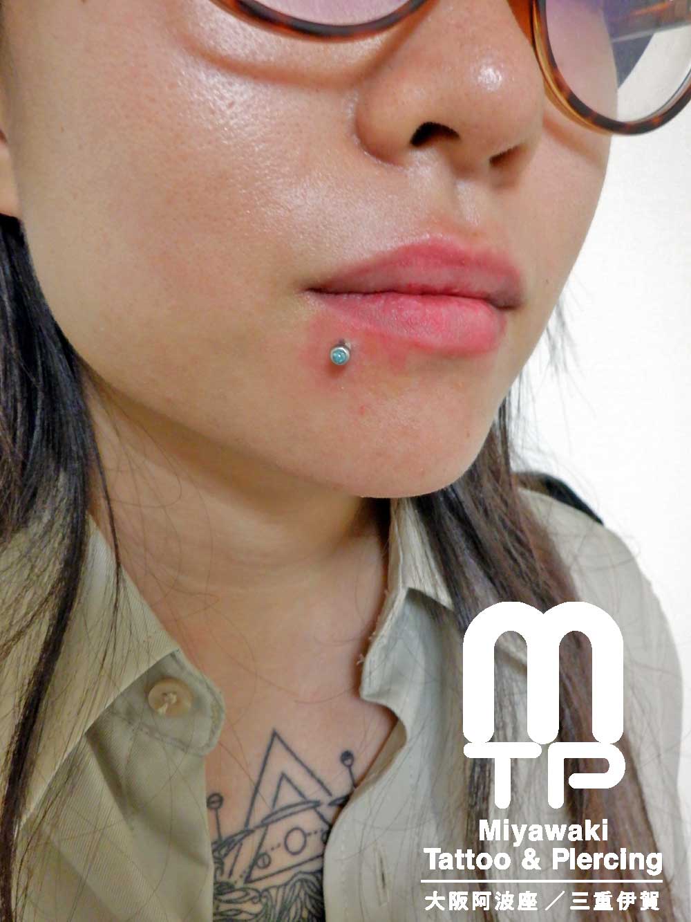 部位及び名称　左唇端に青色のボールがキャッチの浅めのラブレットピアス（リップピアスとの判断でも良いかもな位置）