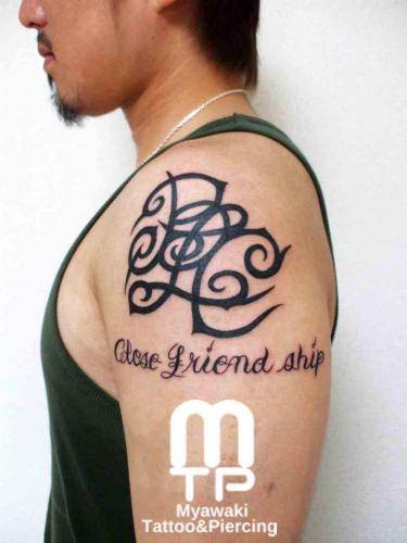 二の腕のカスタムデザインのトライバルと下に文字