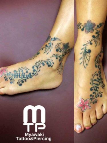 足の甲から足首全体にポリネシアンデザインを使いながらの装飾とプルメリアと文字