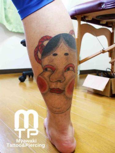 ふくらはぎにお多福の面。逆にある般若を見る目線で