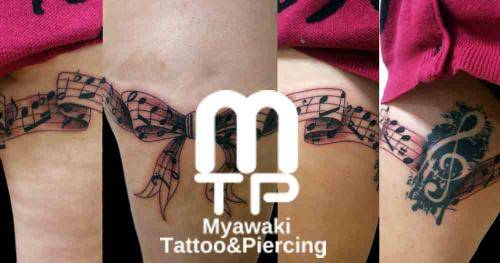 左太もも一周にリボンの楽譜。