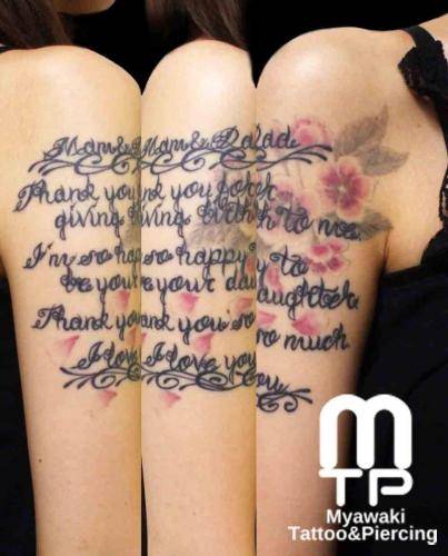 右二の腕から５分にかけて、カスタムレタリング。レタリングの下に挿絵のように淡い色合いでの桜の花と花びら。