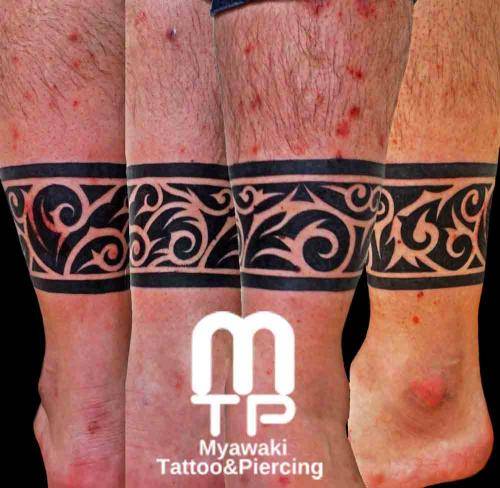 足首一周に黒でのトライバル。色の無い部分もデザインとして。