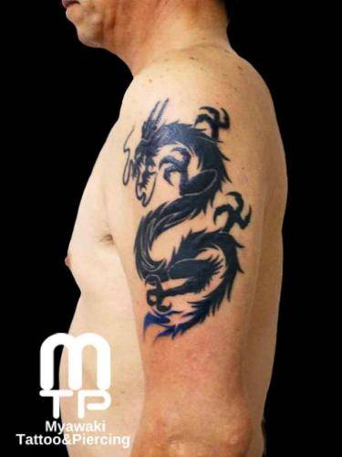 二の腕に黒色でシルエットでの龍。尾は青系のグラデーション。