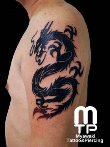 二の腕に黒色でシルエットでの龍。尾はボカシのグラデーション。