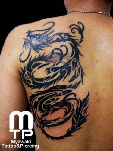 左肩甲骨にボカシも取り入れたトライバルデザインでの黒い龍。