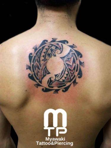 背中上部の真ん中に円形のポリネシアンタトゥー