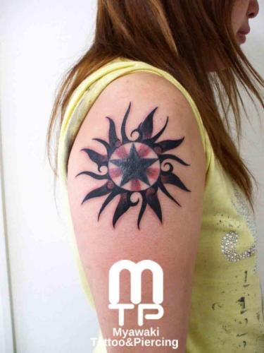 二の腕に太陽をモチーフとしたデザイン。中央に黒い星。